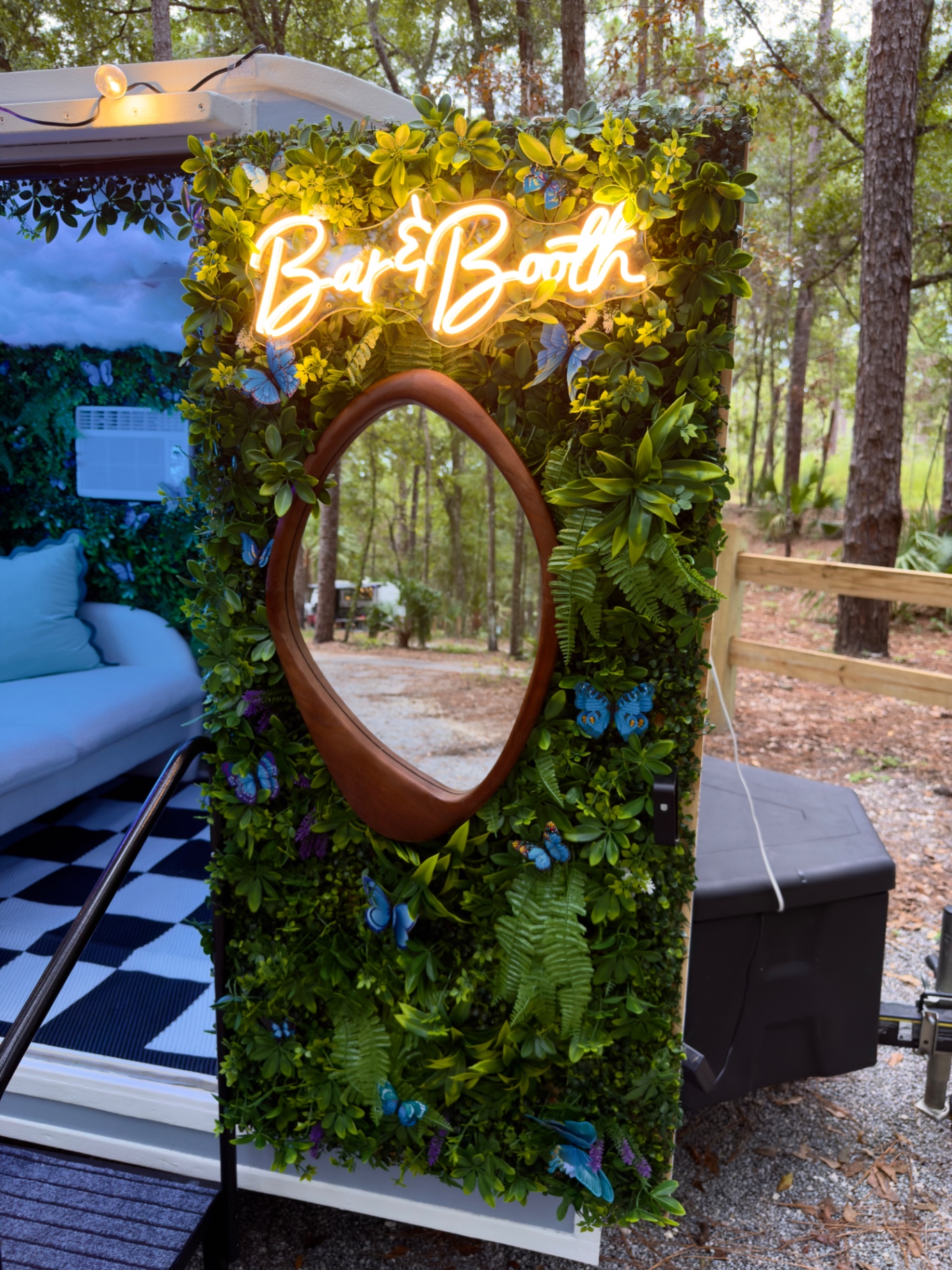Neon Bar&Booth sign on the butterfly grass wall beside the camper photo booth